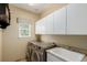 Well-lit laundry room with modern washer and dryer, sink, and storage cabinets at 7852 Solstice Way, Castle Rock, CO 80108