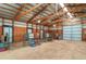 Bright barn interior showcasing stalls, wood beams, metal walls, and dirt floor at 12973 Mesa View Rd, Larkspur, CO 80118