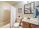 Cozy bathroom with a shower/tub combo, floral shower curtain, single sink vanity at 12973 Mesa View Rd, Larkspur, CO 80118