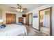 Bright bedroom includes ceiling fan, wood floors, and attached bathroom with vanity and tub at 12973 Mesa View Rd, Larkspur, CO 80118