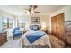 This cozy bedroom features a ceiling fan, natural light, soft carpet, and comfortable furniture at 12973 Mesa View Rd, Larkspur, CO 80118