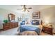 This cozy bedroom features a ceiling fan, natural light, and comfortable furniture at 12973 Mesa View Rd, Larkspur, CO 80118