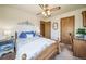 Comfortable bedroom features a wood-framed bed, ensuite bathroom, and closet at 12973 Mesa View Rd, Larkspur, CO 80118