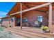 Inviting covered front porch with wooden beams, seating area, and potted plants for outdoor enjoyment at 12973 Mesa View Rd, Larkspur, CO 80118