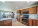 Kitchen with modern stainless steel appliances, wood cabinets, tile floors, and breakfast bar, with a spacious eat-in area at 12973 Mesa View Rd, Larkspur, CO 80118