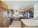 Spacious kitchen featuring stainless steel appliances, wood cabinets, tile floors and natural light from a window at 12973 Mesa View Rd, Larkspur, CO 80118