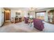 Spacious living room with comfortable seating, carpet flooring, and a view of the outdoor landscape at 12973 Mesa View Rd, Larkspur, CO 80118