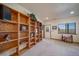 Spacious living room featuring custom built-in shelving and a door to the exterior at 12973 Mesa View Rd, Larkspur, CO 80118