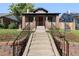 Charming brick home featuring an inviting front porch, manicured lawn, and a welcoming entrance at 3529 N Garfield St, Denver, CO 80205