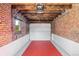 The red floor of the garage adds to the visual appeal, complementing the white walls and wood beam ceiling at 3529 N Garfield St, Denver, CO 80205