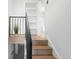 View of the staircase with natural wood steps, black metal railing and decorative plant at 3529 N Garfield St, Denver, CO 80205