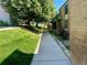 Scenic walkway through the building's landscaped grounds with lush grass and flowers at 3550 S Harlan St # 249, Denver, CO 80235