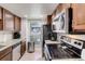 Galley kitchen boasts stainless appliances, granite countertops, and natural light at 3550 S Harlan St # 249, Denver, CO 80235