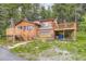Charming log cabin with spacious deck surrounded by lush greenery and a beautifully landscaped yard at 8758 S Murphy Gulch Rd, Littleton, CO 80127