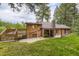 Back view of home with deck, patio, and stone chimney at 8758 S Murphy Gulch Rd, Littleton, CO 80127