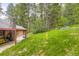 Exterior view of home with stone chimney and wooded lot at 8758 S Murphy Gulch Rd, Littleton, CO 80127