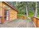 Charming log cabin with an inviting deck, surrounded by lush trees and a serene, grassy landscape at 8758 S Murphy Gulch Rd, Littleton, CO 80127