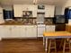 Kitchen with white cabinets, black appliances, and laminate floors at 8758 S Murphy Gulch Rd, Littleton, CO 80127