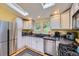 Charming kitchen with white cabinets, stainless steel appliances, granite counters and natural lighting at 8758 S Murphy Gulch Rd, Littleton, CO 80127