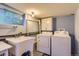 Practical laundry room with a sink, washer, dryer, and ample cabinet space at 8758 S Murphy Gulch Rd, Littleton, CO 80127