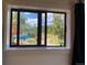 Picture window view showcases a serene outdoor setting with trees, pathway, and a glimpse of a blue car at 8758 S Murphy Gulch Rd, Littleton, CO 80127