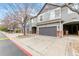 Exterior angle of townhome featuring garage doors and covered entryways in a residential neighborhood at 1461 S Danube Way # 104, Aurora, CO 80017