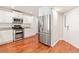 Bright kitchen featuring stainless steel appliances, white cabinets, granite countertops, and hardwood floors at 1461 S Danube Way # 104, Aurora, CO 80017