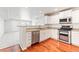 Well-lit kitchen boasts stainless steel appliances, white cabinetry, and granite counters, with hardwood floors at 1461 S Danube Way # 104, Aurora, CO 80017