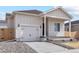 Well-lit front exterior featuring a driveway, garage, and a beautifully designed facade at 5863 Sawdust Dr, Brighton, CO 80601