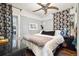 Bedroom with a ceiling fan, a queen bed, and dark curtains at 2469 S Broadway, Denver, CO 80210