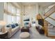 Bright living room with a high ceiling, large windows, modern decor, and a staircase leading to the upper level at 510 Fairhaven St, Castle Rock, CO 80104