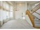 Bright living room boasts soaring ceilings, large windows, elegant chandelier, and staircase with wooden handrail at 510 Fairhaven St, Castle Rock, CO 80104
