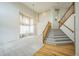 Bright living room boasts soaring ceilings, large windows, elegant chandelier, and staircase with wooden handrail at 510 Fairhaven St, Castle Rock, CO 80104