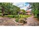 Expansive backyard featuring manicured landscaping, mature trees, a stone walkway, and a large brick home in the background at 12570 W 60Th Ave, Arvada, CO 80004