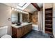 Bathroom featuring dual vessel sinks, stone counters, and dark tile flooring at 12570 W 60Th Ave, Arvada, CO 80004