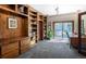 Home office featuring custom built-in wood bookshelves and storage, with a sliding glass door leading to the outside at 12570 W 60Th Ave, Arvada, CO 80004