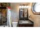 Bathroom with textured walls, vanity, and a tiled shower offering practical functionality at 12570 W 60Th Ave, Arvada, CO 80004