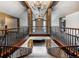Grand interior balcony with stone columns and wrought iron railing overlooking living area at 12570 W 60Th Ave, Arvada, CO 80004