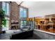 Bright living room featuring a stone fireplace, large windows, an adjacent kitchen, and an open layout for entertaining at 12570 W 60Th Ave, Arvada, CO 80004