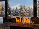 Covered patio with a fire pit and snow covered trees in the background at 12570 W 60Th Ave, Arvada, CO 80004