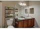Full bathroom featuring a double vanity with granite counters, dark wood cabinets, and a large mirror at 1425 Blue Sky Cir # 15-107, Erie, CO 80516