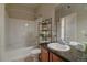 A full bathroom featuring a tiled shower-tub combination, dark wood cabinets, and granite countertop sink at 1425 Blue Sky Cir # 15-107, Erie, CO 80516