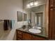 Bathroom with granite counters, wood cabinets, decorative mirror, and tile flooring at 1425 Blue Sky Cir # 15-107, Erie, CO 80516
