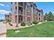 Beautiful apartment building exterior with well-maintained landscaping, stone accents, and private balconies at 1425 Blue Sky Cir # 15-107, Erie, CO 80516