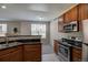 Modern kitchen boasts stainless steel appliances, granite countertops, and hardwood cabinets at 1425 Blue Sky Cir # 15-107, Erie, CO 80516