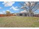 Spacious backyard with a large tree, patio, and a wooden fence offering privacy at 8481 Clarkson St, Denver, CO 80229