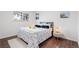 Cozy bedroom featuring hardwood floors, a queen-sized bed with decorative pillows, and wall art at 8481 Clarkson St, Denver, CO 80229