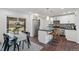 Modern kitchen with stainless steel appliances, a center island with bar seating, and a dining area at 8481 Clarkson St, Denver, CO 80229
