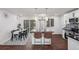 Modern kitchen with breakfast bar, dining table with seating for six, and stainless steel refrigerator at 8481 Clarkson St, Denver, CO 80229