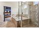 Bathroom featuring a tile surround tub with glass shower, natural light, and neutral color palette at 5352 Truckee St, Denver, CO 80249
